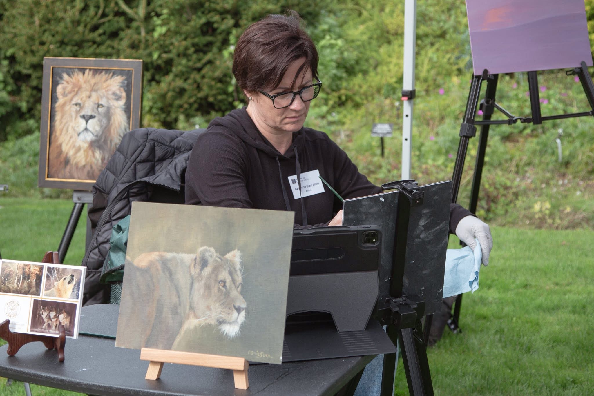 Agnieszka Elliott painting at an outdoor exhibition